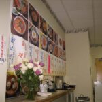 Large menu on the wall and menus at the end of the counter