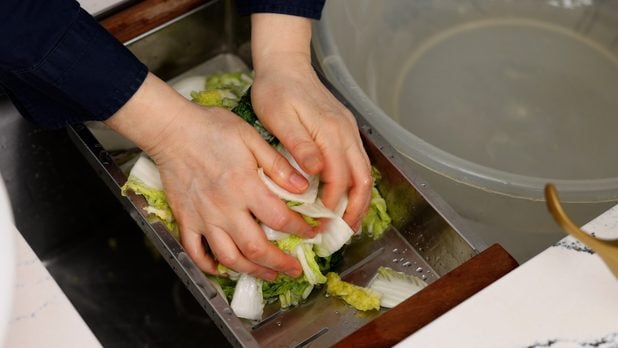 squeezing out excess water from the cabbage